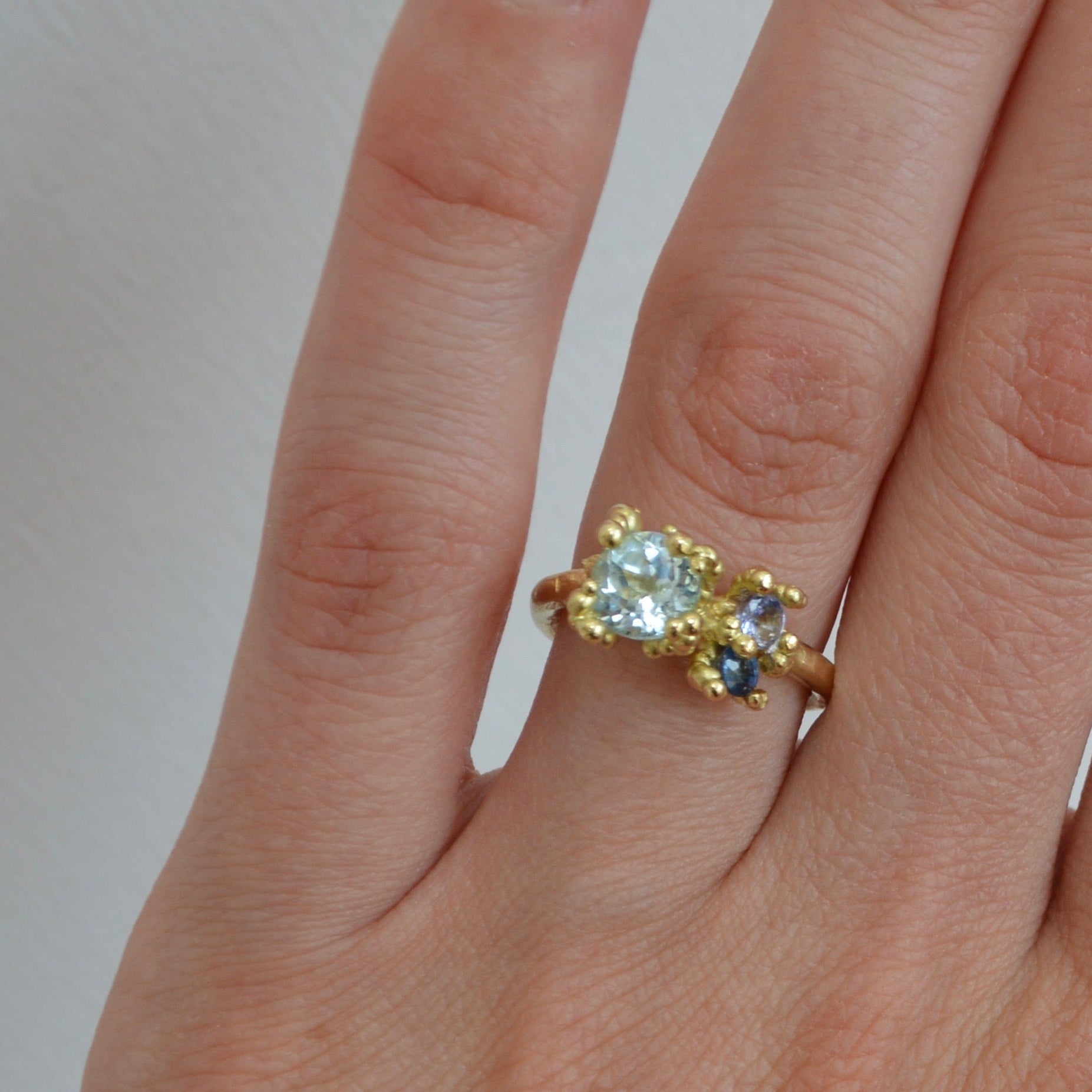 aquamarine tanzanite and sapphire ring in 14ct yellow gold with beaded setting.