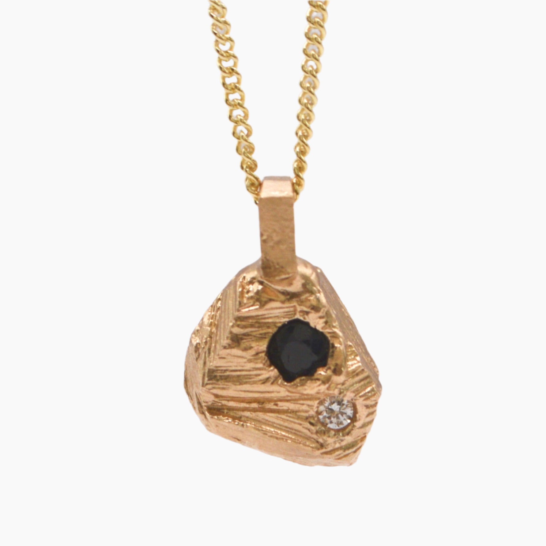 textured rock pendant featuring sapphire and diamond.